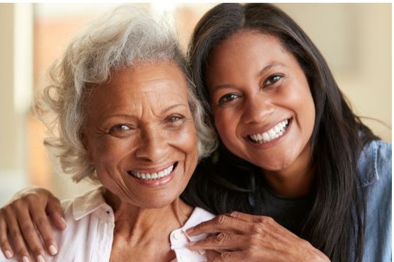 Caregiver and family member smiling together